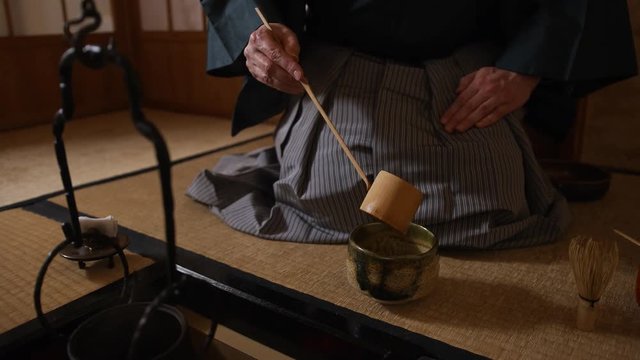 Japanese tea ceremony, the Way of Tea. Tea master pours water into a cup (chawan)