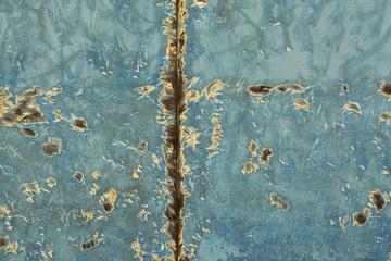 texture of blue wall with yellow spots of paint and rust