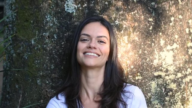 Sexy young woman posing and playing with hair in park