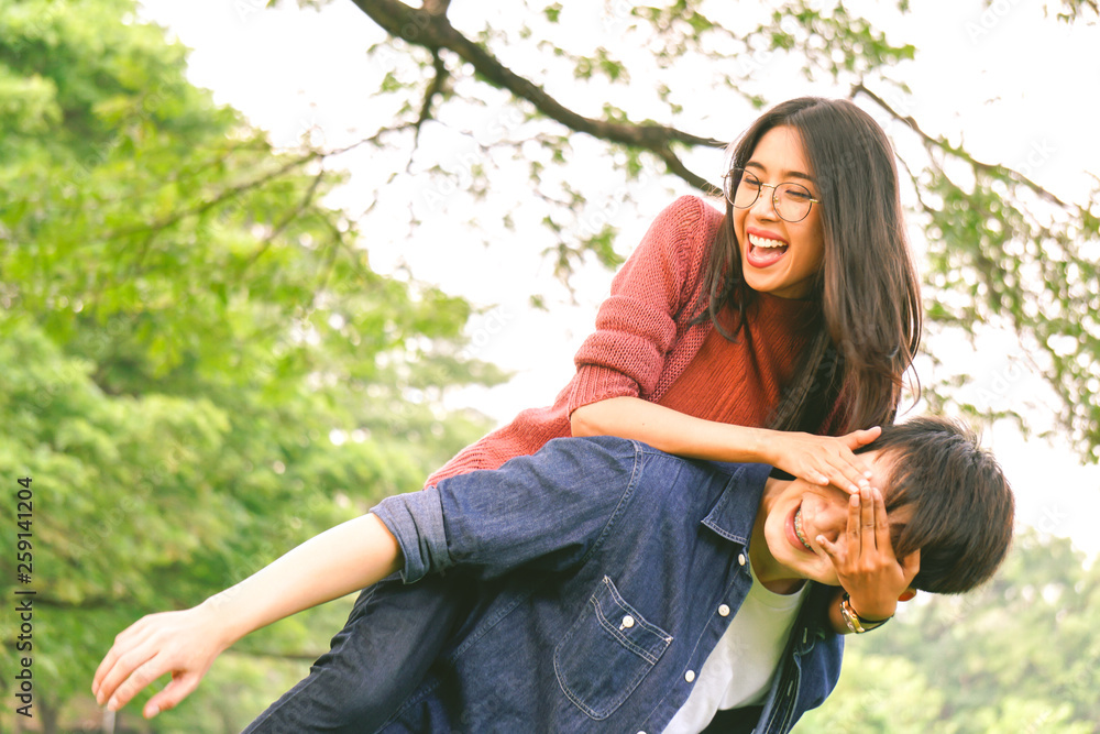 Wall mural Asian love couple in park with happiness, laugh and smile