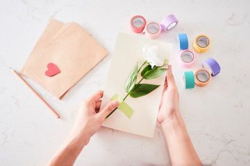 Hands of woman making birthday card, view from the top