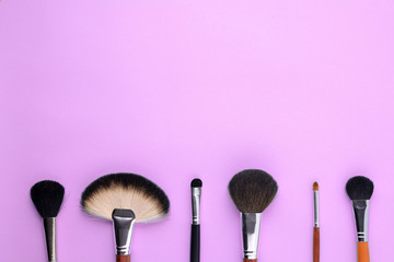makeup brushes on a pink background. Top view, flat lay, copy space