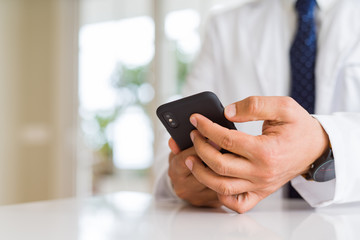 Close up middle age doctor man hands using smartphone