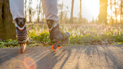 Close view to inline skates . Outdoor inline skating on smooth concrete ground. Spring Background...