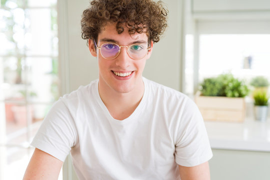 Young handsome man wearing glasses with a happy and cool smile on face. Lucky person.