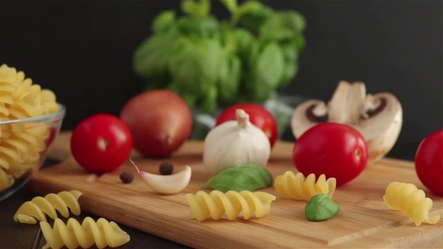 pasta ingreidents slider video.fusilli cherry tomatoes basil garlic mushroom on wooden table