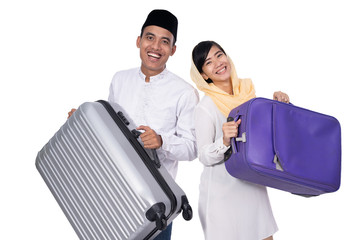 muslim asian couple with travel suitcase. going for ramadan eid mubarak celebration concept