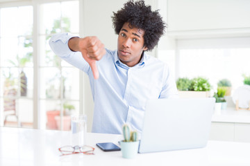 African American business man working using laptop with angry face, negative sign showing dislike with thumbs down, rejection concept