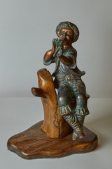 statuette of a a boy who plays the bronze flute