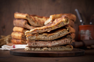 Various Traditional Ossetian meat pies with beef, chicken and salmon on a wooden background