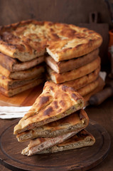 Various Traditional Ossetian meat pies with beef, chicken and salmon on a wooden background
