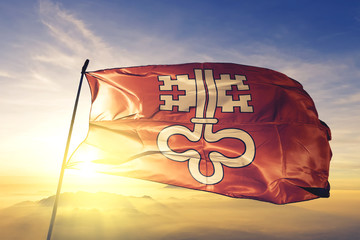Nidwalden canton of Switzerland flag waving on the top sunrise mist fog