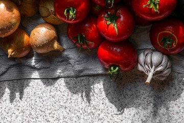 Ripe fresh harvested vegetables on table. Onions, tomatoes, garlic, pepper. Making delicious vegetarian meal or canning veggies for winter in jars. Concept of healthy eating