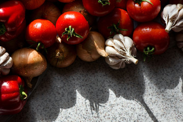 Ripe fresh harvested vegetables on table. Onions, tomatoes, garlic, pepper. Making delicious vegetarian meal or canning veggies for winter in jars. Concept of healthy eating