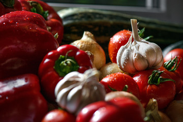 Ripe fresh harvested vegetables on table. Onions, tomatoes, garlic, pepper, zucchini in kitchen. Making delicious vegetarian meal or canning veggies for winter in jars. Concept of healthy eating