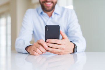 Close up of man hands using smartphone and smiling