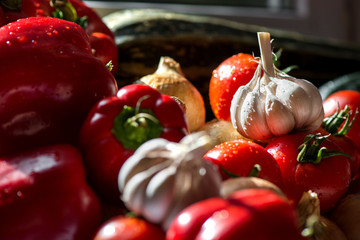 Ripe fresh harvested vegetables on table. Onions, tomatoes, garlic, pepper, zucchini in kitchen. Making delicious vegetarian meal or canning veggies for winter in jars. Concept of healthy eating