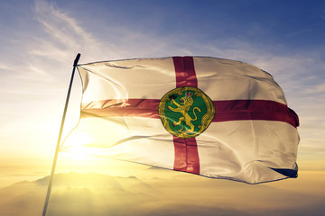 Alderney flag waving on the top sunrise mist fog