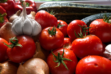Ripe fresh harvested vegetables on table. Onions, tomatoes, garlic, pepper, zucchini in kitchen. Making delicious vegetarian meal or canning veggies for winter in jars. Concept of healthy eating
