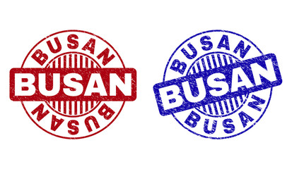 Grunge BUSAN round stamp seals isolated on a white background. Round seals with grunge texture in red and blue colors. Vector rubber watermark of BUSAN text inside circle form with stripes.