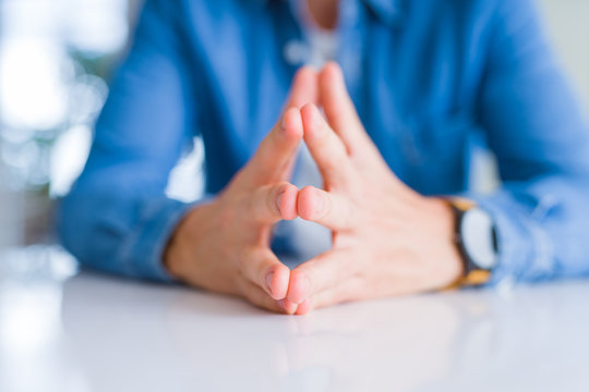 Close up of man hands with palms together over white table