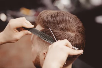 Foto op Aluminium Close-up, meesterkapper doet kapsel met schaarkam. Concept Barbershop © Parilov
