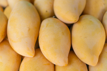 Closed up a bunch of mangoes on street market background.