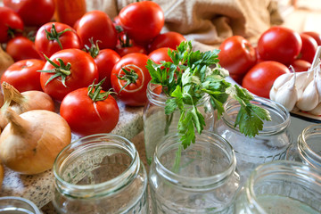 Canning fresh tomatoes with onions in jelly marinade. Woman hands putting red ripe tomato slices and onion rings in jars. Basil, parsley leaves on top of onions. Vegetable salads for winter