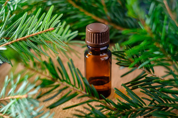 Bottle of pine essential oil on wooden table