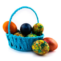Easter eggs in a blue basket isolated on white background