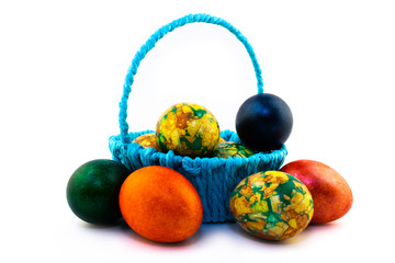Easter eggs in a blue basket isolated on white background