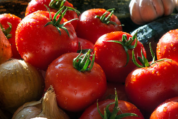 Ripe fresh harvested vegetables on table. Onions, tomatoes, garlic, pepper, zucchini in kitchen. Making delicious vegetarian meal or canning veggies for winter in jars. Concept of healthy eating