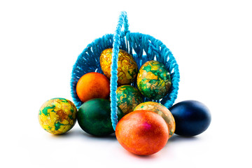 Easter eggs in a blue basket isolated on white background