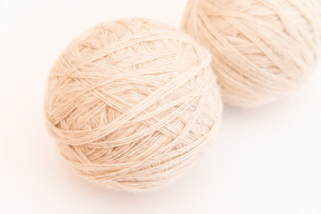 a ball of beige or white wool for knitting and hobbies on a white background