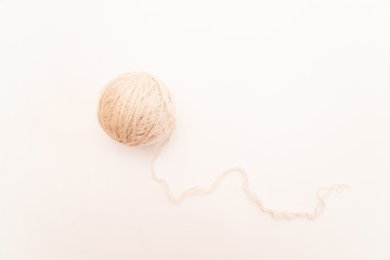 a ball of beige or white wool for knitting and hobbies on a white background