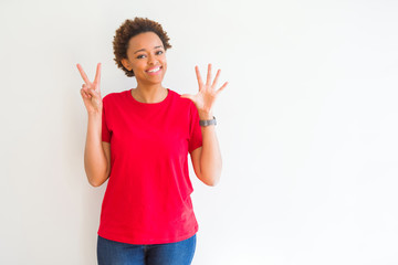 Young beautiful african american woman over white background showing and pointing up with fingers number seven while smiling confident and happy.