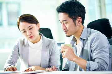 two asian business people working together in office