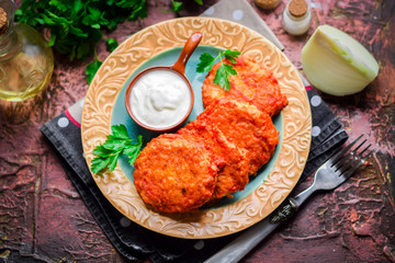 Chicken chops with rice with tomato sauce and sour cream.