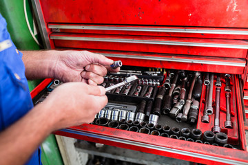 Auto mechanic taking tool from toolbox