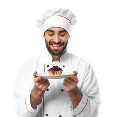 Male confectioner with tasty dessert on white background