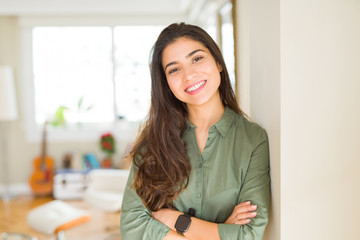 Beautiful brunette woman smiling cheerful, looking happy and positive with crossed arms