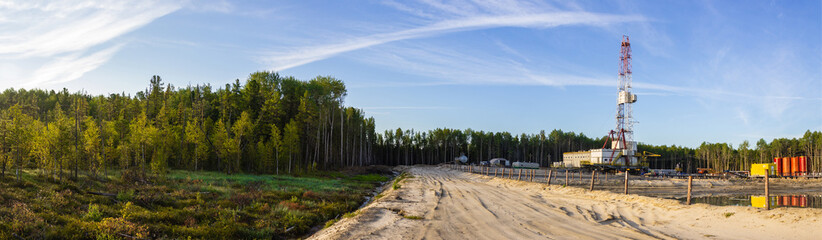 a panorama of a drilling rig on a sand dumping in the forest in the morning