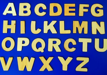 wooden letters of the Latin alphabet on a blue background