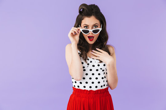 Image of content pin-up woman 20s in vintage polka dot dress and retro sunglasses smiling at camera