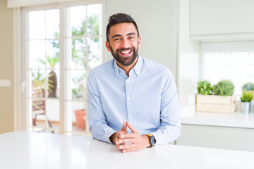 Handsome hispanic business man Hands together and fingers crossed smiling relaxed and cheerful....