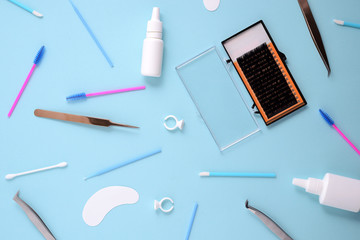 makeup brushes and cosmetics on a blue background. Top view, flat lay