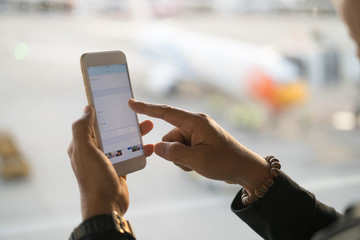 Man using smart phone checking airline at Airport