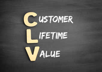 Obraz premium Wooden alphabets building the word CLV - Customer Lifetime Value acronym on blackboard