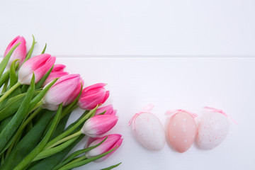 Pink Tulips and Easter Eggs isolated on white wood Background.