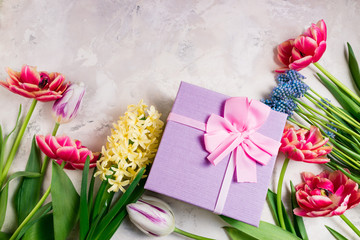 Festive background with flowers and gift box. Tulips and present. Holidays, Easter, happy birthday, mother's day, anniwarsary, wedding, mother's day, congratulations card concept. Flat lay. Top view
